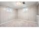 Basement with updated gray wood paneling, neutral carpet, and two windows for lighting at 4534 W 65Th Ave, Arvada, CO 80003