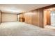 Finished basement with carpet, wood paneling, built-in bar, and access to the bathroom at 4534 W 65Th Ave, Arvada, CO 80003