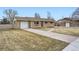 Ranch-style brick house with an attached garage, driveway, and landscaping at 4534 W 65Th Ave, Arvada, CO 80003