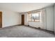 Bright living room with gray carpet, neutral walls, a bay window with curtains, and hardwood entryway at 4534 W 65Th Ave, Arvada, CO 80003