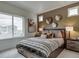 Comfortable bedroom with a queen-sized bed, nightstands, and ample natural light from a large window at 13161 E 103Rd Pl, Commerce City, CO 80022