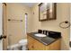 This bathroom features a granite countertop, wooden cabinets, and modern fixtures at 3801 Oak St, Wheat Ridge, CO 80033