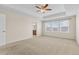 Large bedroom features a tray ceiling with fan, neutral carpet and paint, and bright windows at 22898 E Saratoga Pl, Aurora, CO 80015