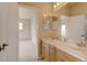 Bright bathroom with double vanity, tile floors, and view into bedroom with neutral carpet at 1864 Malibu Ct, Fort Lupton, CO 80621