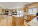 Bright open-concept kitchen with island, stainless steel appliances, and hardwood floors at 1864 Malibu Ct, Fort Lupton, CO 80621