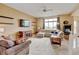 Comfortable living room with a fireplace, entertainment center and large windows at 1864 Malibu Ct, Fort Lupton, CO 80621