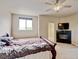 Comfortable primary bedroom with a fireplace, TV, a ceiling fan, and access to a walk-in closet at 1864 Malibu Ct, Fort Lupton, CO 80621