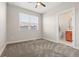 Carpeted bedroom with neutral walls, modern ceiling fan and an en-suite bathroom at 1071 Oak Cir, Lakewood, CO 80215