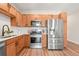 Modern kitchen equipped with stainless steel appliances, light wood cabinets, and elegant countertops perfect for cooking at 1071 Oak Cir, Lakewood, CO 80215