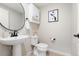 Clean powder room offering a pedestal sink, modern fixtures, a framed art print, and essential storage at 1071 Oak Cir, Lakewood, CO 80215