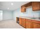 Basement bar area with countertop, cabinets, sink, and adjacent carpeted space at 5721 S Jellison St, Littleton, CO 80123