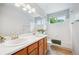 Bathroom with double sinks, a large mirror, white tile surround, and a window for natural light at 5721 S Jellison St, Littleton, CO 80123