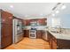 Well-equipped kitchen featuring stainless steel appliances, rich wooden cabinetry and granite countertops at 5721 S Jellison St, Littleton, CO 80123
