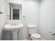 Charming powder room with pedestal sink, new toilet and mirror at 5721 S Jellison St, Littleton, CO 80123