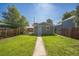 Private fenced backyard with lush lawn, features a back entrance and a sitting area at 3968 Winona Ct, Denver, CO 80212