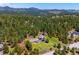 Overhead shot of a property with a house, garage, lush trees, and mountain views at 8045 S Wagon Wheel Rd, Morrison, CO 80465
