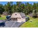 Aerial view of the home featuring garage, driveway, and surrounding mature trees at 8045 S Wagon Wheel Rd, Morrison, CO 80465