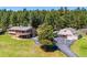 Sprawling property featuring multiple buildings, a circular driveway, lush lawn, and views of surrounding trees at 8045 S Wagon Wheel Rd, Morrison, CO 80465