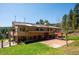 Backyard featuring a brick patio with a porch swing, green lawn, and mature trees at 8045 S Wagon Wheel Rd, Morrison, CO 80465