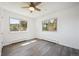 Bright bedroom with hardwood floors, ceiling fan, and windows looking out onto trees at 8045 S Wagon Wheel Rd, Morrison, CO 80465
