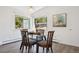 Charming dining room with a glass table set by large windows, offering natural light and outdoor views at 8045 S Wagon Wheel Rd, Morrison, CO 80465