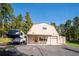 Exterior of garage featuring driveway and surrounding mature trees at 8045 S Wagon Wheel Rd, Morrison, CO 80465