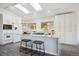 Bright kitchen boasting white cabinetry, a granite island with seating, and stainless steel appliances at 8045 S Wagon Wheel Rd, Morrison, CO 80465