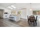 Modern kitchen featuring a granite island with seating, white cabinetry, stainless steel appliances, and dining area at 8045 S Wagon Wheel Rd, Morrison, CO 80465