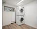 Laundry room featuring wood look floors and a stacked washer and dryer set at 8045 S Wagon Wheel Rd, Morrison, CO 80465