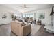 Bright living room featuring large windows, comfortable seating, and a sliding glass door to the outdoor deck at 8045 S Wagon Wheel Rd, Morrison, CO 80465