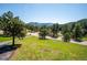 Scenic home site boasting mature trees, green lawn and surrounding mountains at 8045 S Wagon Wheel Rd, Morrison, CO 80465