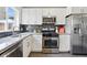Bright kitchen featuring stainless steel appliances, granite countertops, and mosaic backsplash at 2821 N Harrison St, Denver, CO 80205