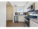 Modern kitchen with white cabinetry, stainless steel appliances, granite countertops, and stylish backsplash at 2821 N Harrison St, Denver, CO 80205