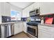 Well-lit kitchen with stainless steel appliances, granite counters, and ample cabinet space at 2821 N Harrison St, Denver, CO 80205