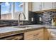 Close-up of kitchen sink, granite countertop, and mosaic backsplash at 2821 N Harrison St, Denver, CO 80205