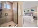 Contemporary glass shower showing the doorway to the bedroom with lots of natural light at 2466 S Cherokee St, Denver, CO 80223