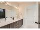 Bright bathroom featuring double sinks, wood cabinets, and modern lighting fixtures at 2466 S Cherokee St, Denver, CO 80223