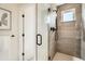 Modern shower with glass door and a view of the bathroom door and artwork at 2466 S Cherokee St, Denver, CO 80223