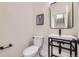 Modern powder room with a black framed mirror and sleek fixtures at 2466 S Cherokee St, Denver, CO 80223