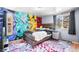 This bedroom has a colorful accent wall, natural light, and wooden floors at 21 Snowmass Pl, Longmont, CO 80504