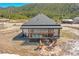 Aerial view of modern home with hot tub and fire pit on patio with mountain backdrop at 499 Silver Creek Rd, Idaho Springs, CO 80452