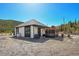 Modern home with black trim and a pergola covered patio in a mountain setting at 499 Silver Creek Rd, Idaho Springs, CO 80452
