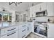 Kitchen featuring stainless steel appliances, white cabinets, and an expansive quartz countertop at 499 Silver Creek Rd, Idaho Springs, CO 80452