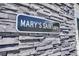 Close-up of the decorative black and white MARY'S SAINTuary sign mounted on the stone wall at 499 Silver Creek Rd, Idaho Springs, CO 80452