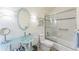 Bathroom featuring an oval mirror, glass countertop sink, toilet, and shower-tub combo at 461 Fillmore St, Denver, CO 80206