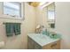 Bathroom with light blue accents, glass countertop sink and window providing natural light at 461 Fillmore St, Denver, CO 80206