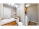 Functional bathroom with a single sink vanity, toilet, and a laundry area with a washing machine for convenience at 5308 S Ukraine St, Aurora, CO 80015