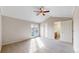 Well-lit bedroom featuring vaulted ceiling, ceiling fan, glass doors to a balcony, and an ensuite bathroom at 5308 S Ukraine St, Aurora, CO 80015