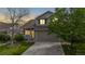 Charming two-story home with a well-maintained lawn, mature trees, and a two-car garage at dusk at 5308 S Ukraine St, Aurora, CO 80015