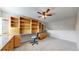 Spacious carpeted home office featuring a ceiling fan and built-in cabinets, desk, shelving and drawers at 5308 S Ukraine St, Aurora, CO 80015